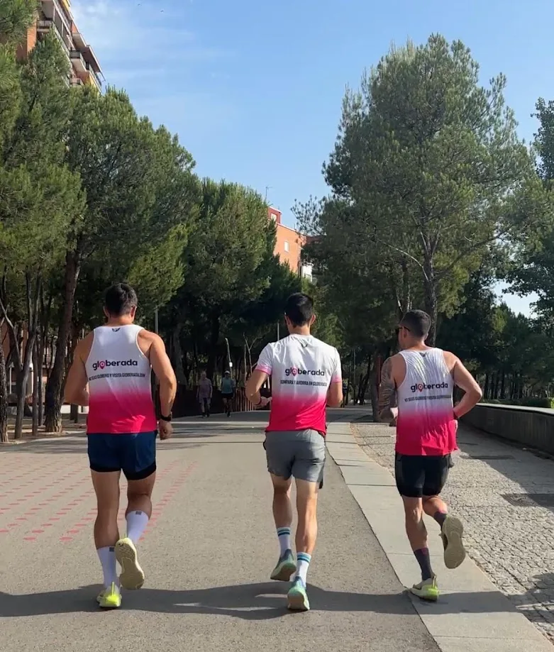 Three runners wearing Globerada shirts on a tree-lined path