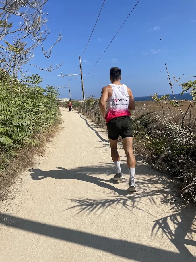Running along a coastal trail wearing a Globerada shirt