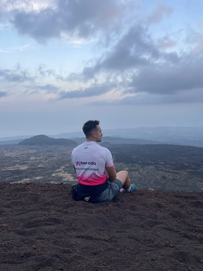 Sitting on a volcanic landscape wearing a Globerada shirt